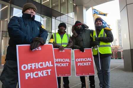Four male PCS members holding OFFICIAL PICKET placards