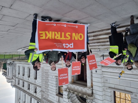 Members holding PCS ON STRIKE banner