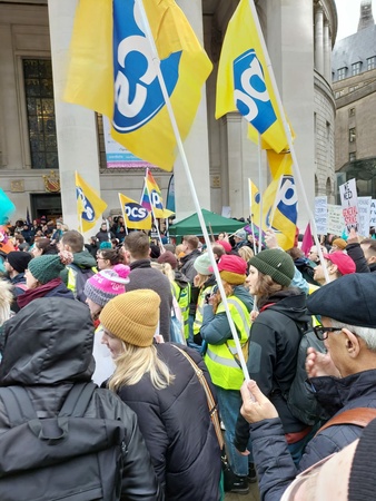 Photo shows crowd of people with PCS flags