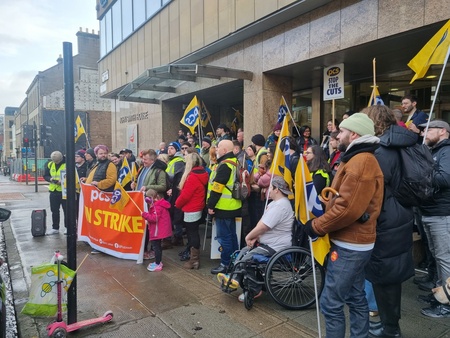 Photo shows group of people with PCS ON STRIKE banner 