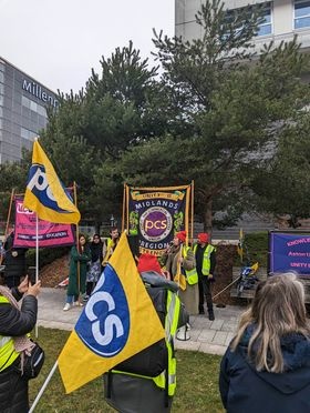 Image shows PCS members with a banner, flags and a UCU banner