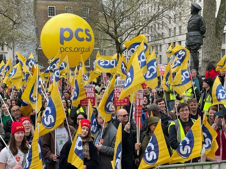 Multiple flags and the PCS balloon at the strike rally opposite Downing Street
