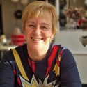 Jackie has short blonde hair and is smiling at the camera
