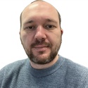 Steve wears a grey top and has a short beard