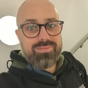 Lee has a beard and glasses