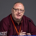 Martin is sitting in front of a microphone, talking