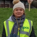 Helen is wearing a yellow high vis jacket and a scarf and bobble hat